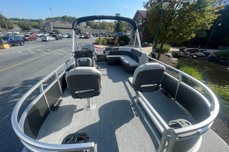 Slide: The Image of 2026 Sun Tracker Bass Buggy 16 XL Select pontoon boat in a parking lot setting. - 2