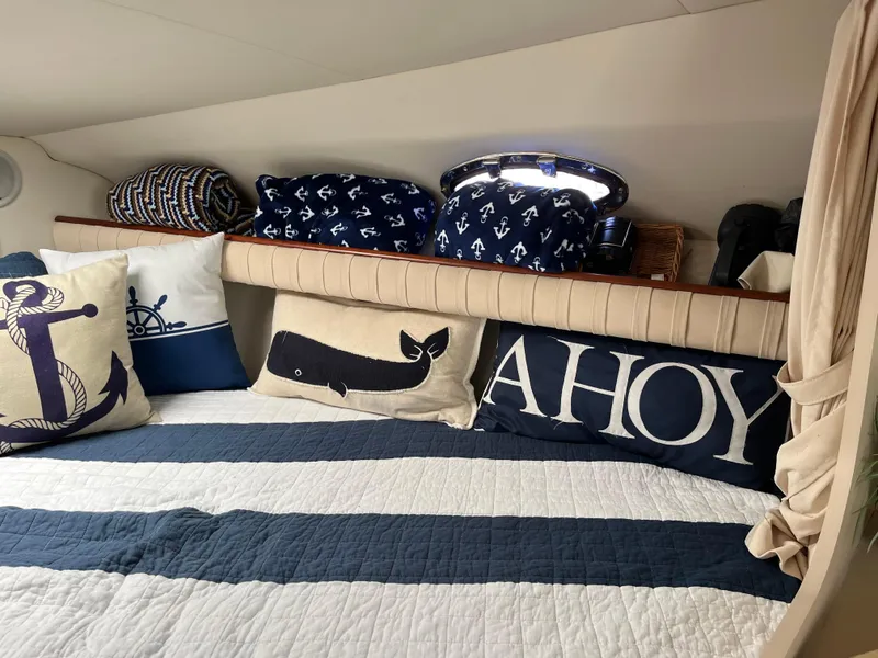 Slide: The Image of 2001 Cruisers Yachts 2870 Express cabin with nautical-themed bedding and decorative pillows. - 22