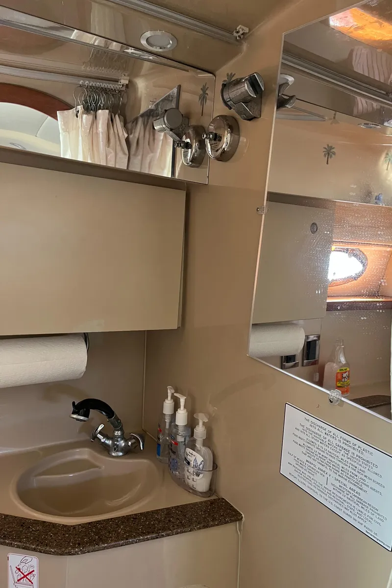 Slide: The Image of 2001 Cruisers Yachts 2870 Express bathroom with sink, mirror, and toiletries. - 32