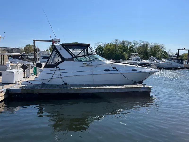 The Image of 2001 Cruisers Yachts 2870 Express docked at marina under clear blue sky. - 1