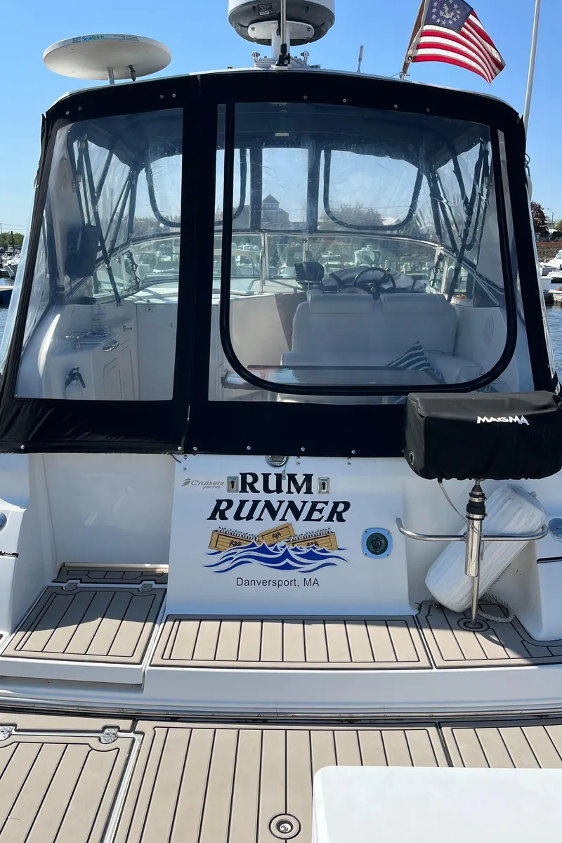 Slide: The Image of 2001 Cruisers Yachts 2870 Express boat with "Rum Runner" name, docked with American flag. - 24