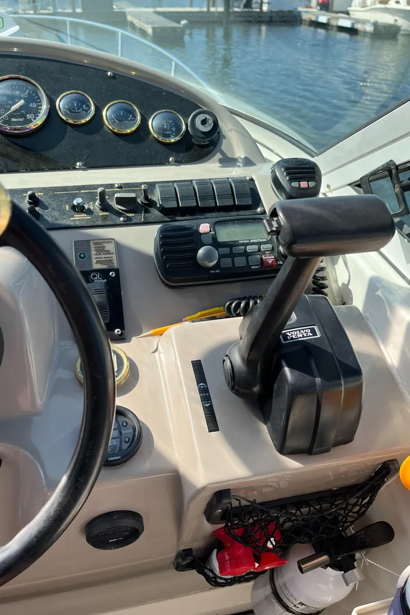 Slide: The Image of 2001 Cruisers Yachts 2870 Express helm with controls and gauges, docked by the water. - 26