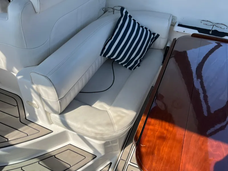 Slide: The Image of 2001 Cruisers Yachts 2870 Express interior with white seating and striped pillow. - 9