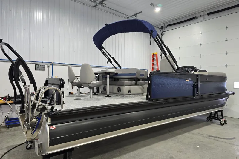 Slide: The Image of 2025 Premier 250 Sunsation RS pontoon boat in a garage setting. - 10
