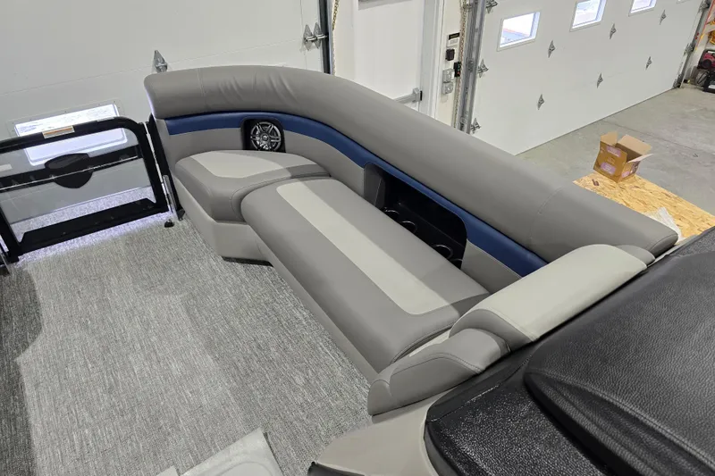 Slide: The Image of 2025 Premier 250 Sunsation RS boat interior with gray and blue seating in a garage. - 14