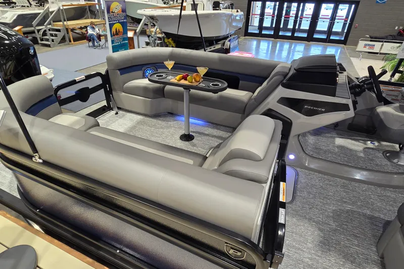 Slide: The Image of 2025 Premier 250 Sunsation RS pontoon boat interior with plush seating and refreshments. - 26