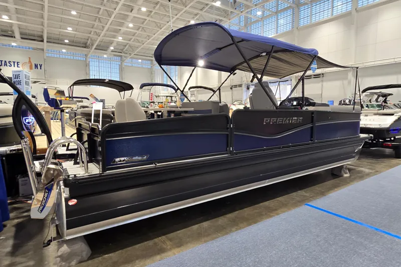 Slide: The Image of 2025 Premier 250 Sunsation RS pontoon boat displayed indoors at a boat show. - 3