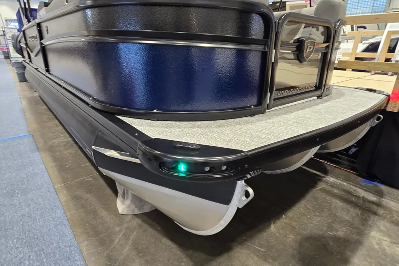 Slide: The Image of 2025 Premier 250 Sunsation RS pontoon boat, sleek design, showcased indoors. - 8