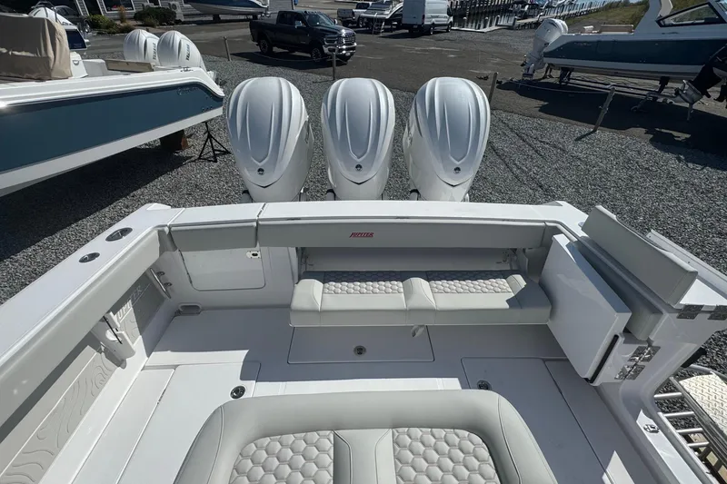 Slide: The Image of 2026 Jupiter 34 boat with quad engines, spacious seating, and modern design in a marina setting. - 10