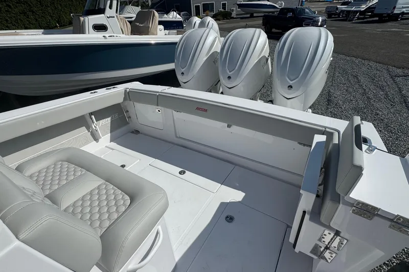Slide: The Image of 2026 Jupiter 34 boat with triple outboard engines and luxurious seating. - 11