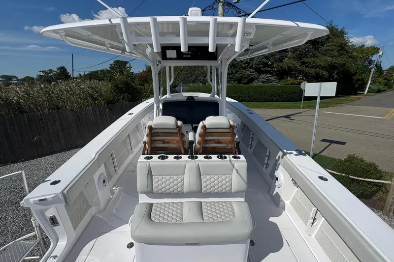 Slide: The Image of 2026 Jupiter 34 boat with sleek design and luxurious seating, docked outdoors. - 17