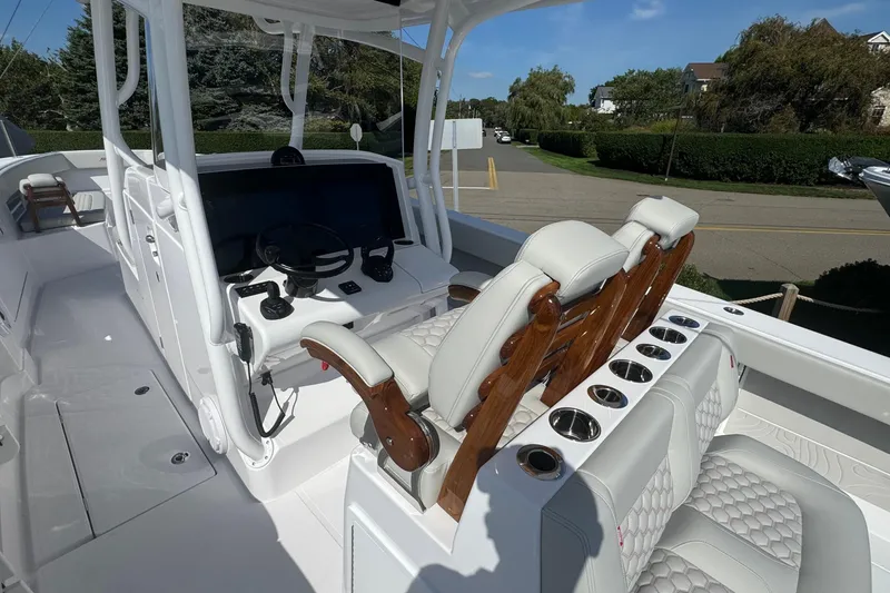 Slide: The Image of 2026 Jupiter 34 boat interior with modern helm, luxurious seating, and cup holders. - 22