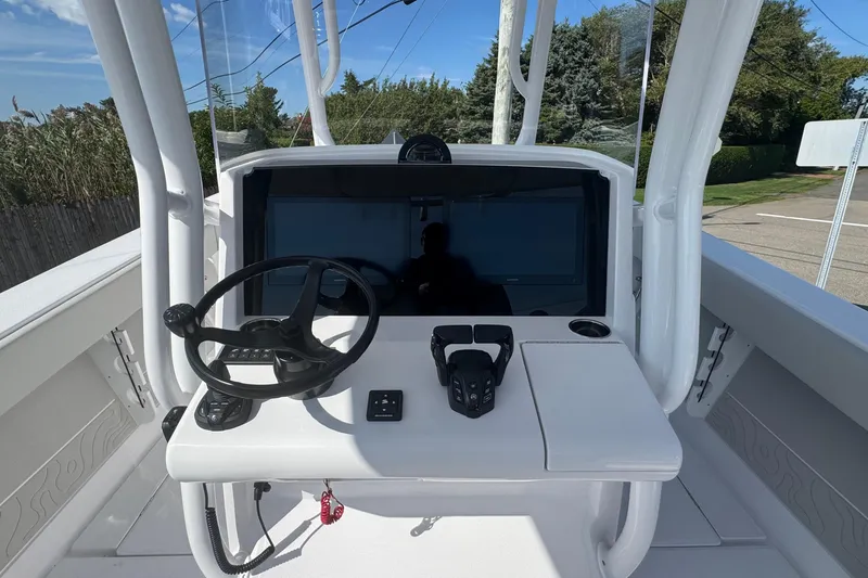 Slide: The Image of 2026 Jupiter 34 boat helm with steering wheel and control panel, outdoor setting. - 28