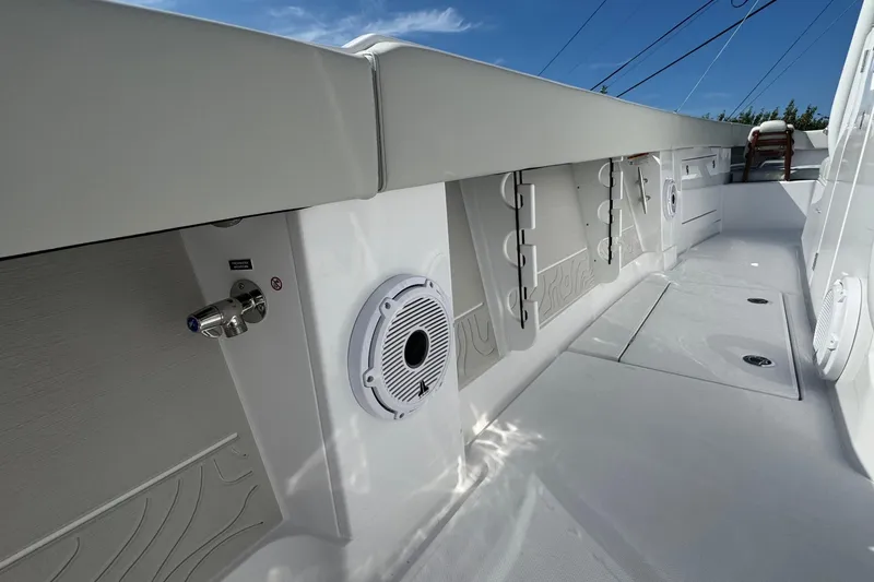 Slide: The Image of 2026 Jupiter 34 boat interior with speakers and storage compartments under a clear blue sky. - 29