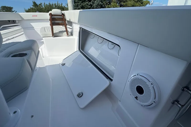 Slide: The Image of 2026 Jupiter 34 boat interior with open storage compartment and speaker. - 34