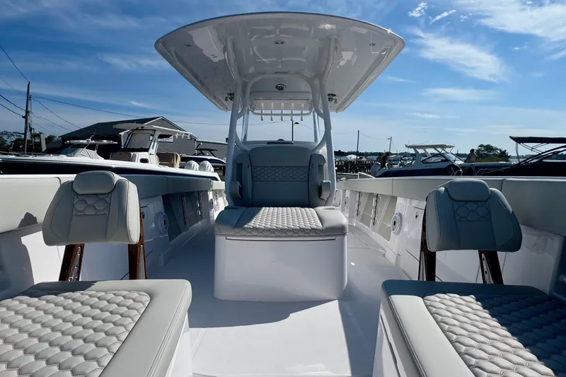 Slide: The Image of 2026 Jupiter 34 boat interior with cushioned seating and sleek design under a clear sky. - 42