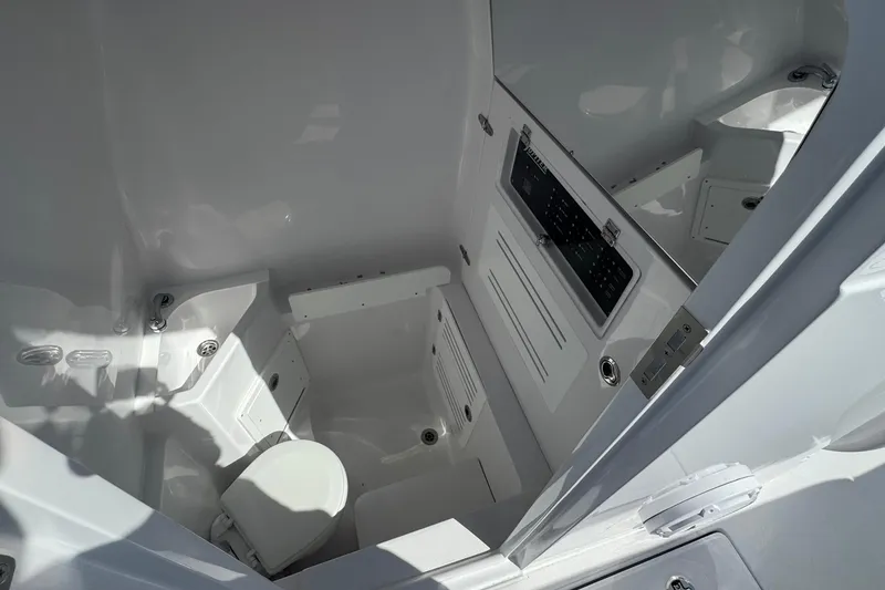 Slide: The Image of Interior of 2026 Jupiter 34 boat, featuring a compact, modern bathroom with toilet and control panel. - 46
