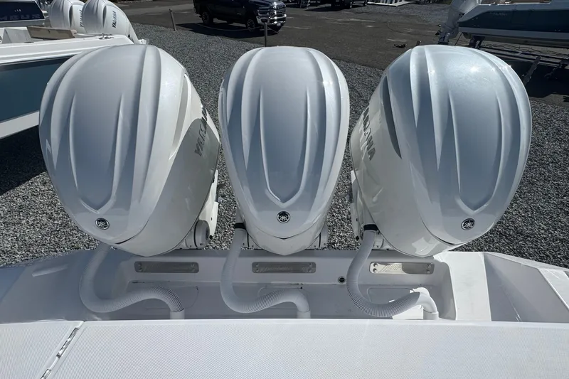 Slide: The Image of Triple outboard engines on a 2026 Jupiter 34 boat, parked on gravel. - 7