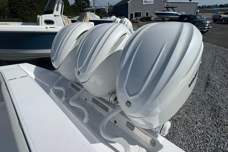Slide: The Image of Triple outboard engines on a 2026 Jupiter 34 boat, parked on gravel. - 8