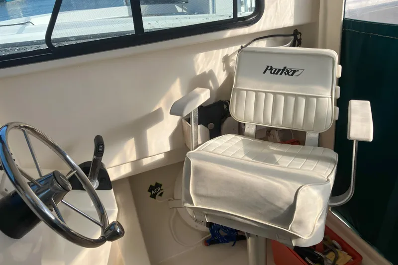 Slide: The Image of 2001 Parker 2520 Sport Cabin interior with steering wheel and branded captain's chair. - 23