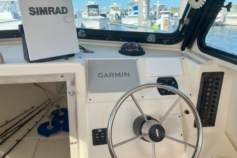 Slide: The Image of 2001 Parker 2520 Sport Cabin helm with Garmin and Simrad navigation systems. - 26