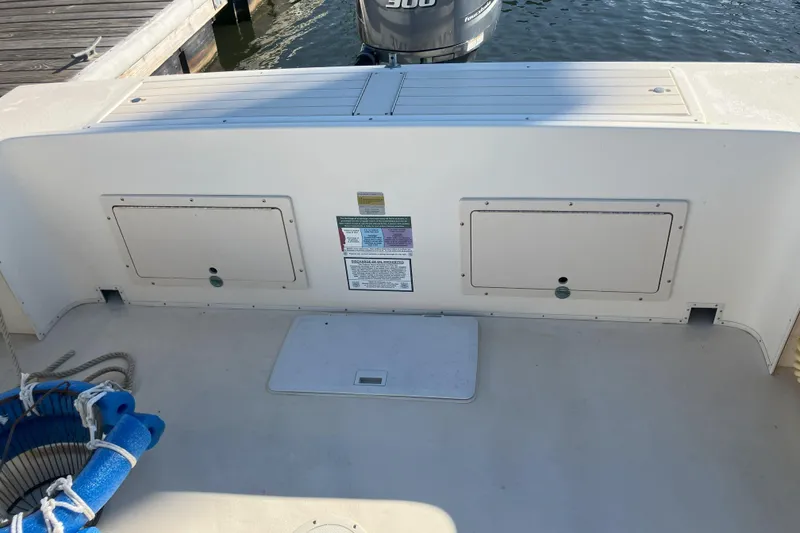 Slide: The Image of 2001 Parker 2520 Sport Cabin boat deck with storage compartments and dock view. - 27