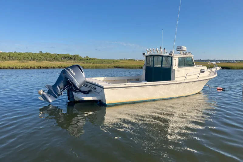 Slide: The Image of 2001 Parker 2520 Sport Cabin boat with Yamaha outboard motor on calm water. - 3