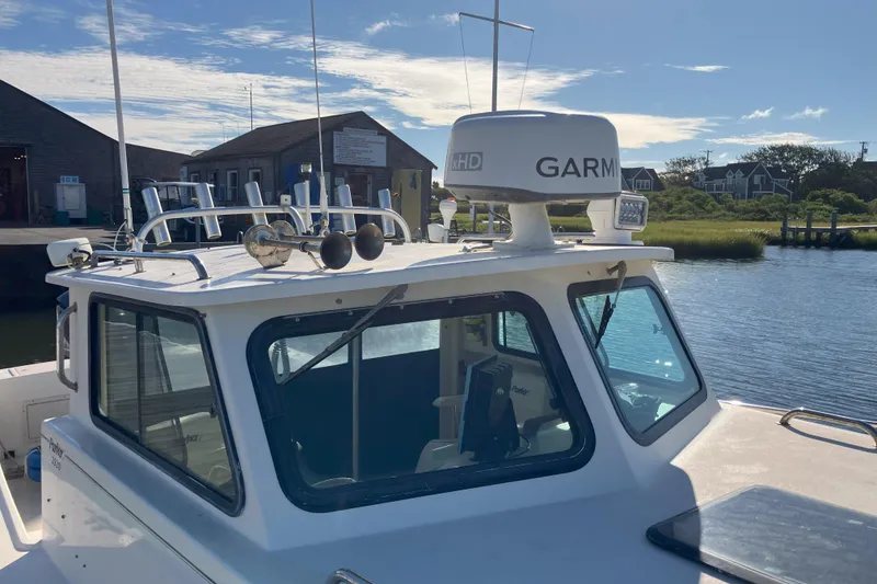 Slide: The Image of 2001 Parker 2520 Sport Cabin boat with Garmin radar, docked by a scenic waterfront. - 7