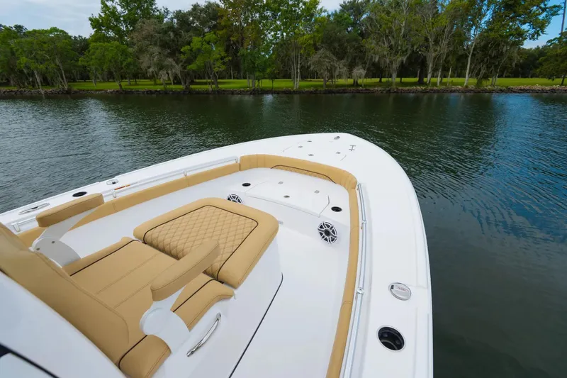 Slide: The Image of 2025 Sportsman Masters 267OE Bay Boat interior with dual seats and storage, docked by waterfront. - 4