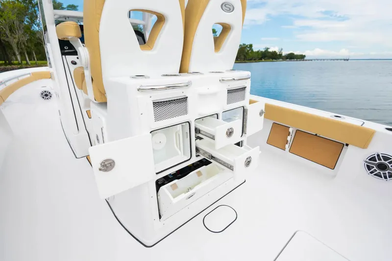 Slide: The Image of 2025 Sportsman Masters 267OE Bay Boat with luxurious white seating at a marina. - 7