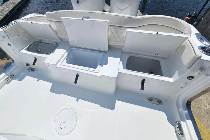 Slide: The Image of 2026 Sea Hunt Ultra 265 SE boat deck with open storage compartments. - 10