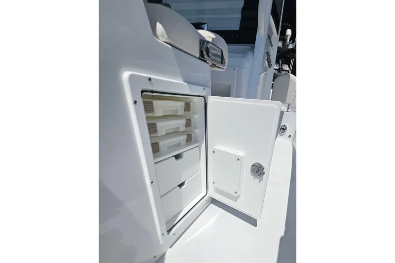 Slide: The Image of 2026 Sea Hunt Ultra 265 SE boat storage compartment with open door. - 18