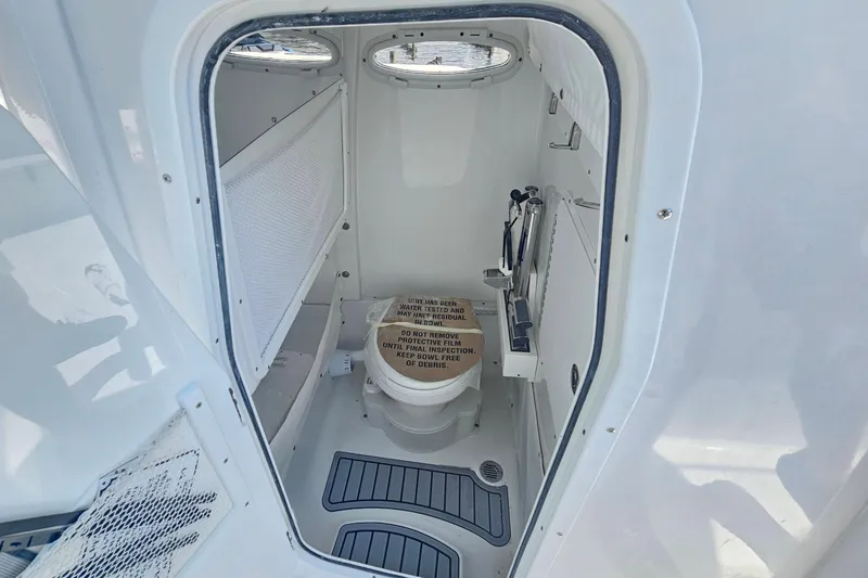 Slide: The Image of Interior of 2026 Sea Hunt Ultra 265 SE boat bathroom with toilet and storage. - 24
