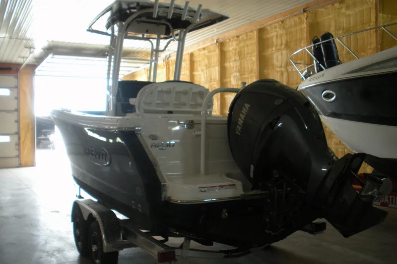Slide: The Image of 2025 Robalo R230 Center Console boat in indoor storage, featuring Yamaha outboard motor. - 2
