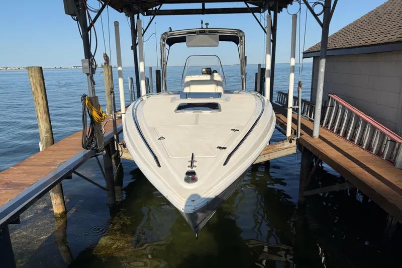 Slide: The Image of 1995 Wellcraft Scarab Sport 302 boat docked on a lift over calm water. - 10