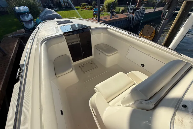 Slide: The Image of 1995 Wellcraft Scarab Sport 302 boat interior with white seating and storage compartments. - 15