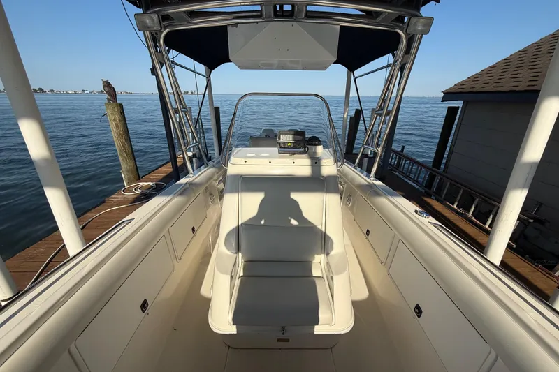 Slide: The Image of 1995 Wellcraft Scarab Sport 302 boat docked by the water, showcasing interior seating and controls. - 16