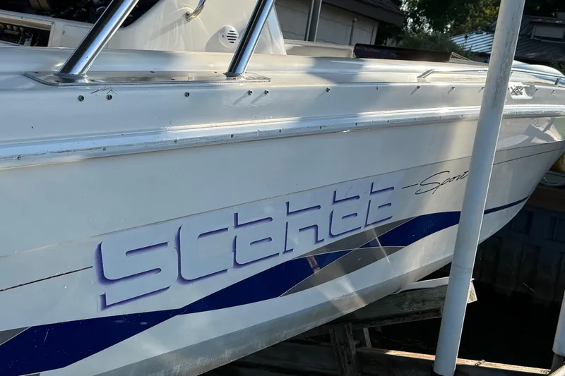 Slide: The Image of 1995 Wellcraft Scarab Sport 302 boat with blue and white design details. - 19