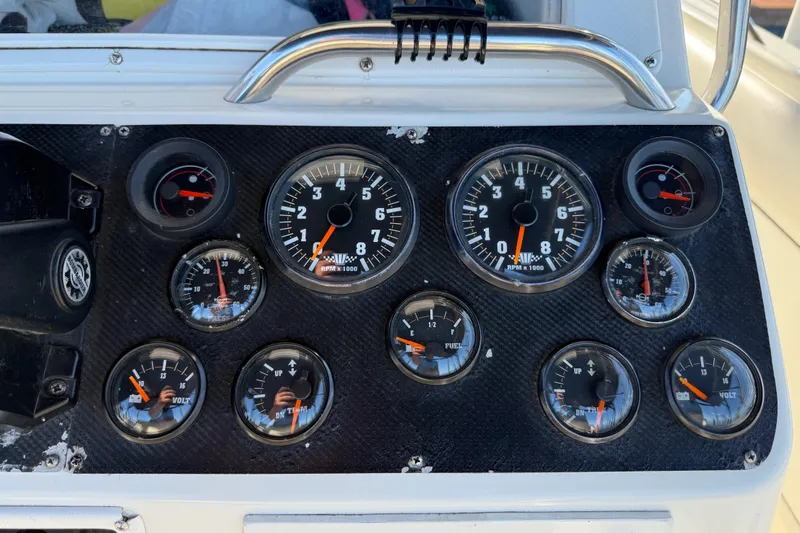 Slide: The Image of Dashboard of a 1995 Wellcraft Scarab Sport 302 boat with various gauges and dials. - 27