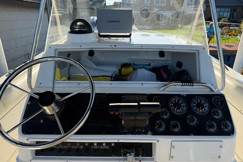 Slide: The Image of 1995 Wellcraft Scarab Sport 302 boat dashboard with steering wheel and gauges. - 28