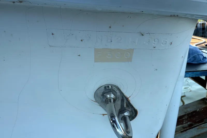 Slide: The Image of 1995 Wellcraft Scarab Sport 302 boat hull with visible serial number and metal fitting. - 29