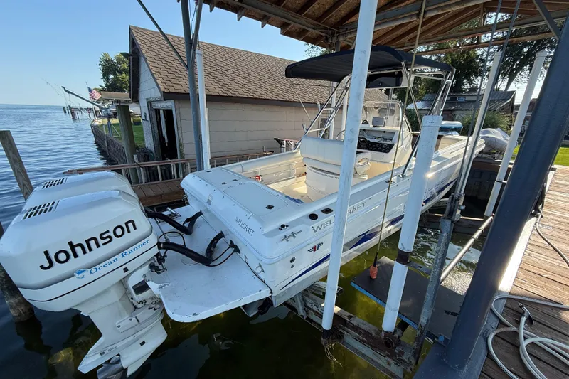 Slide: The Image of 1995 Wellcraft Scarab Sport 302 boat with Johnson Ocean Runner engines on a lift. - 3