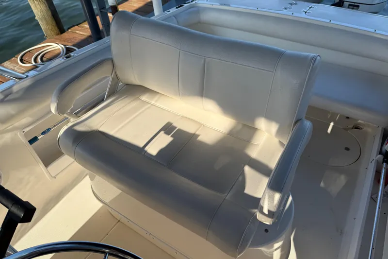 Slide: The Image of 1995 Wellcraft Scarab Sport 302 boat interior with white cushioned seating. - 8