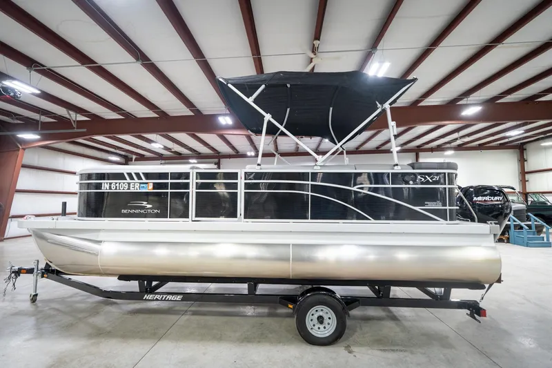Slide: The Image of 2021 Bennington 21 SLX pontoon boat with Mercury engine in indoor showroom. - 11