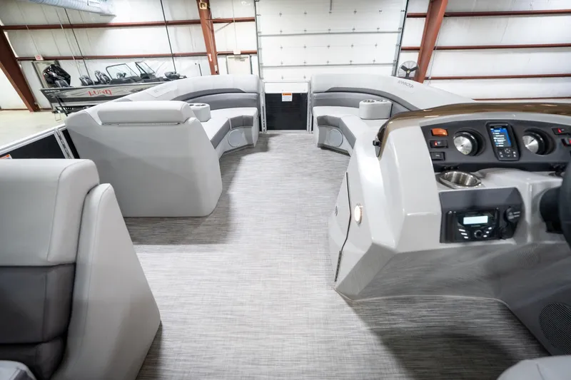 Slide: The Image of 2021 Bennington 21 SLX pontoon boat interior with seating and steering console in a showroom. - 20