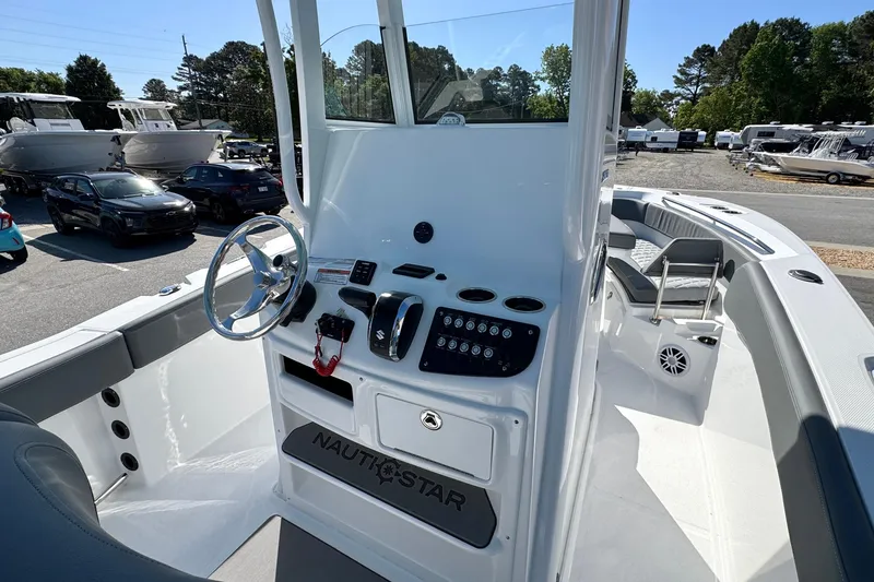 Slide: The Image of 2026 NauticStar 242 Offshore boat cockpit with steering wheel and control panel. - 13