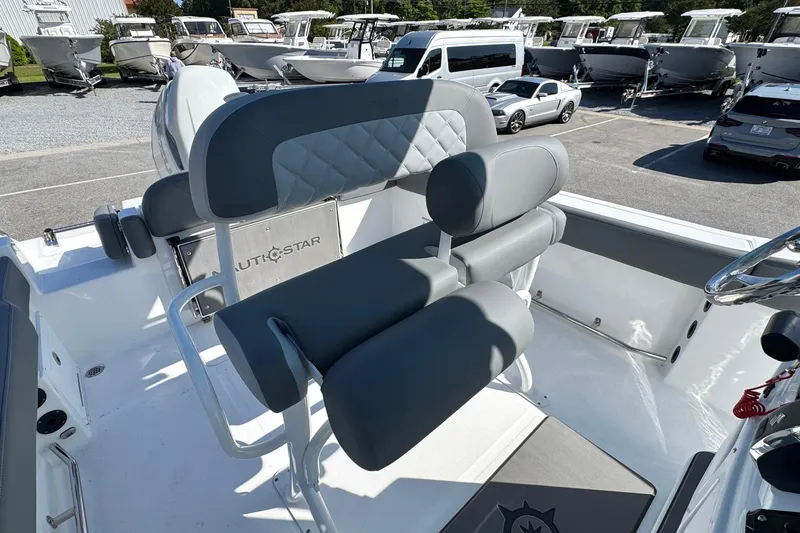 Slide: The Image of 2026 NauticStar 242 Offshore boat interior with gray seating and steering wheel. - 14