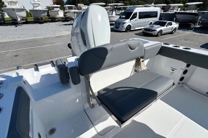 Slide: The Image of 2026 NauticStar 242 Offshore boat interior with seating and motor, parked in a marina. - 16