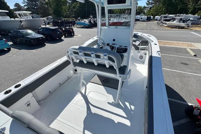 Slide: The Image of 2026 NauticStar 242 Offshore boat interior with seating and console, parked outdoors. - 18