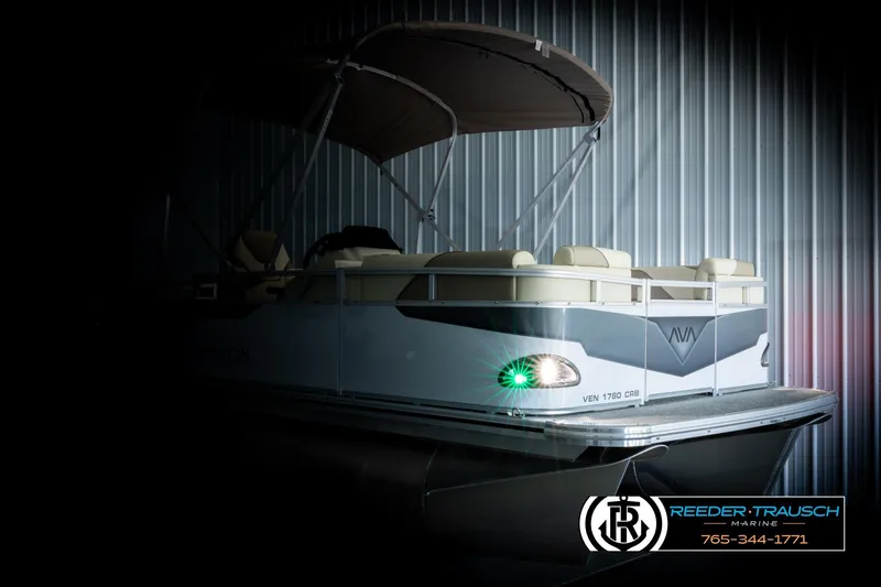 Slide: The Image of 2026 Avalon VEN CRB pontoon boat in a dimly lit showroom. - 4